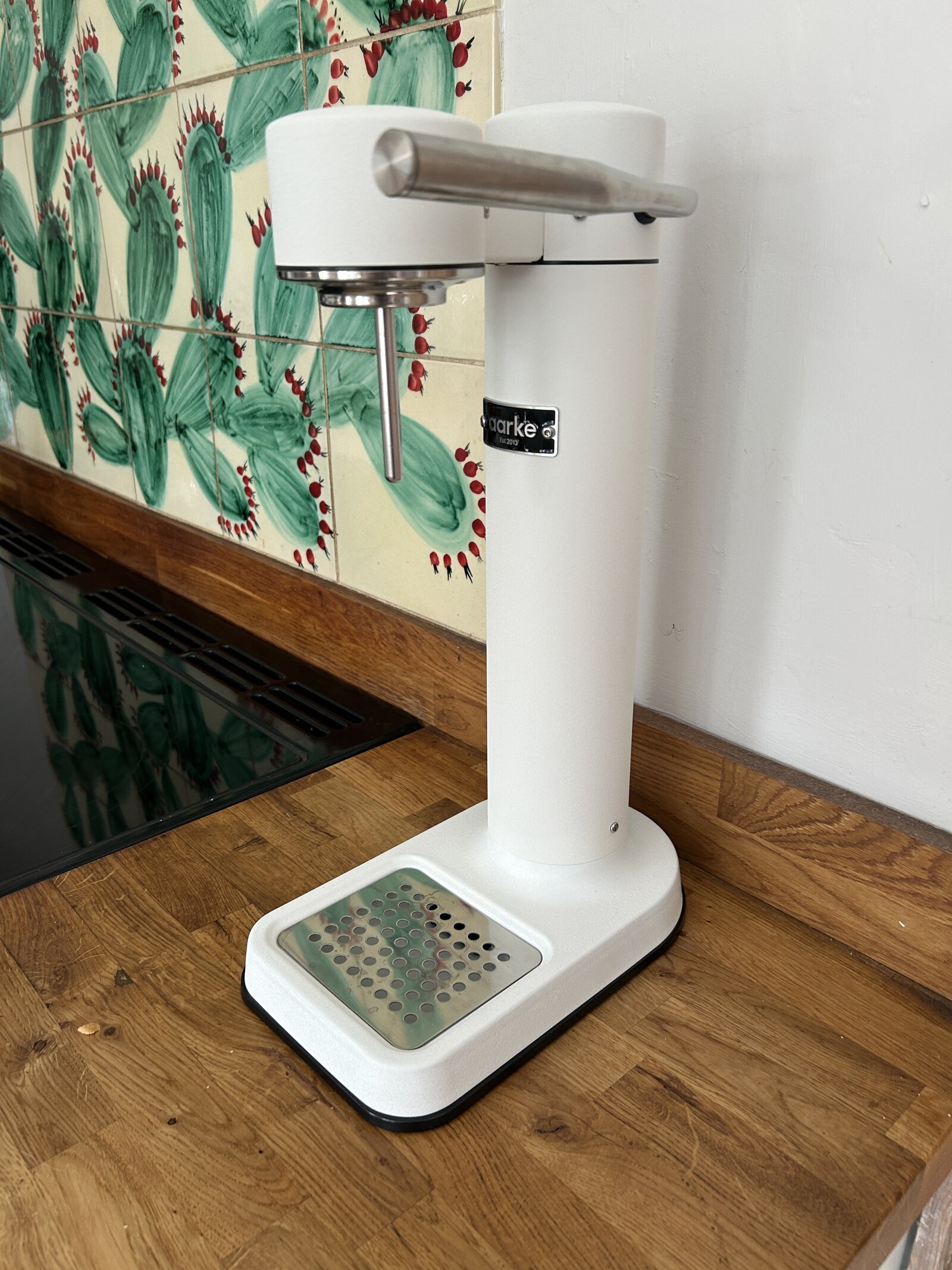 Aarke Carbonator 3 on the kitchen counter, straight on, against cactus-print tiles