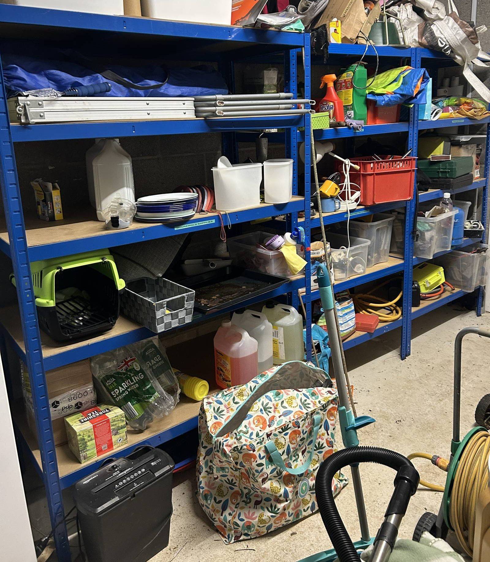 Top of a BiGDUG shelving unit used as a workbench, with a toolbox, drill and mallet