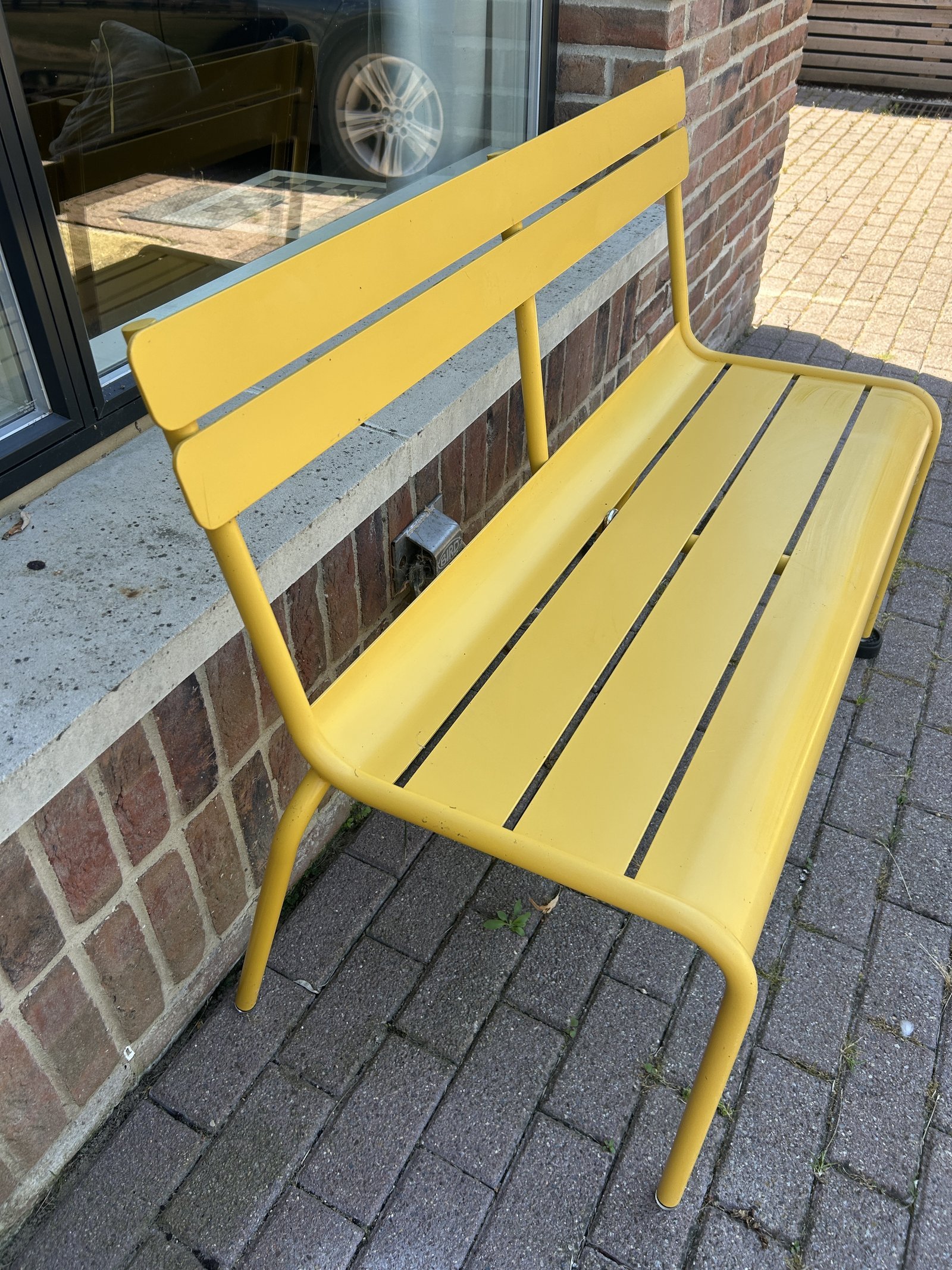 Fermob Luxembourg bench in yellow at the front of the house