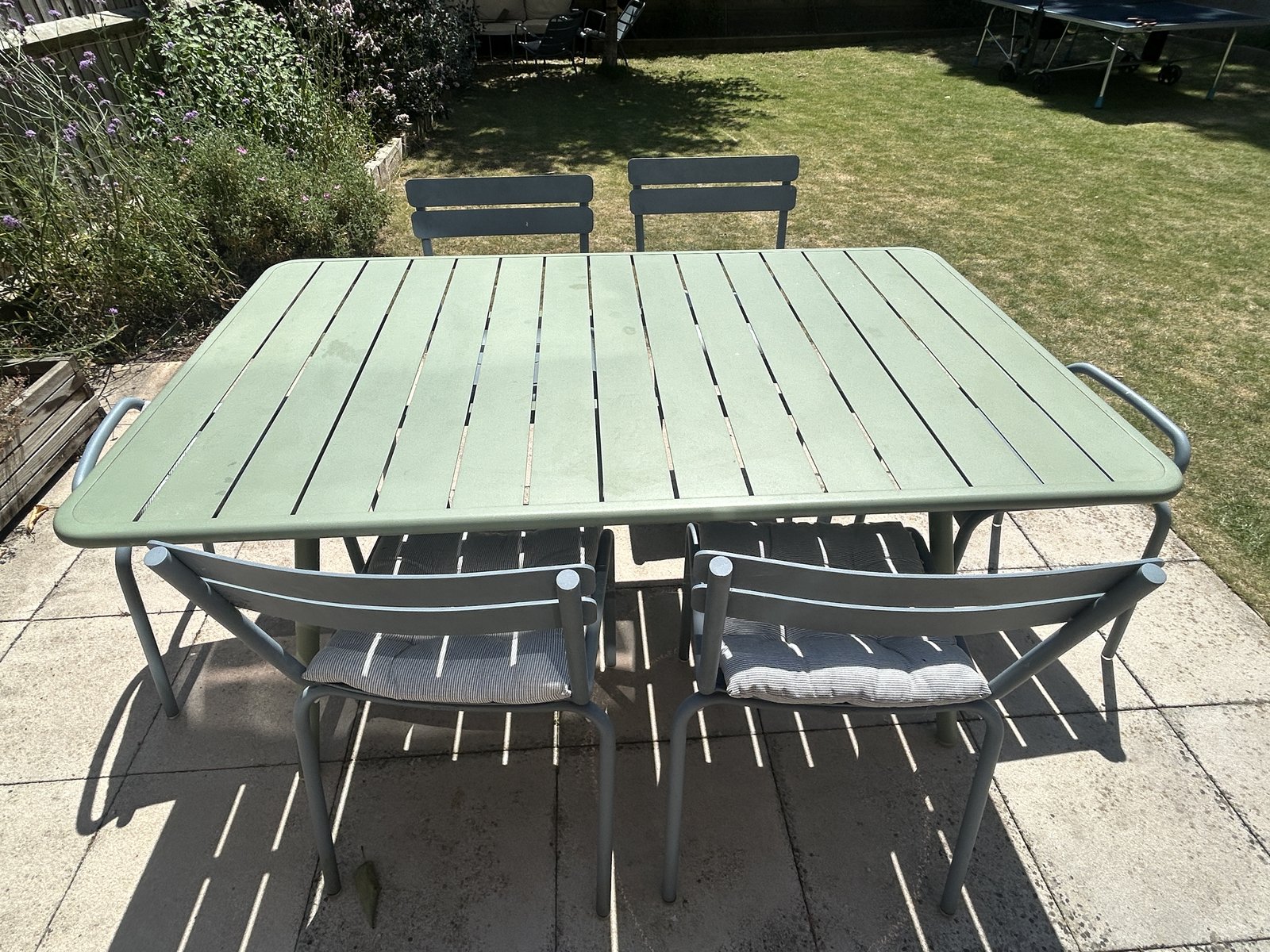 Fermob Luxembourg table and chairs in Cactus and Storm Grey on a garden patio