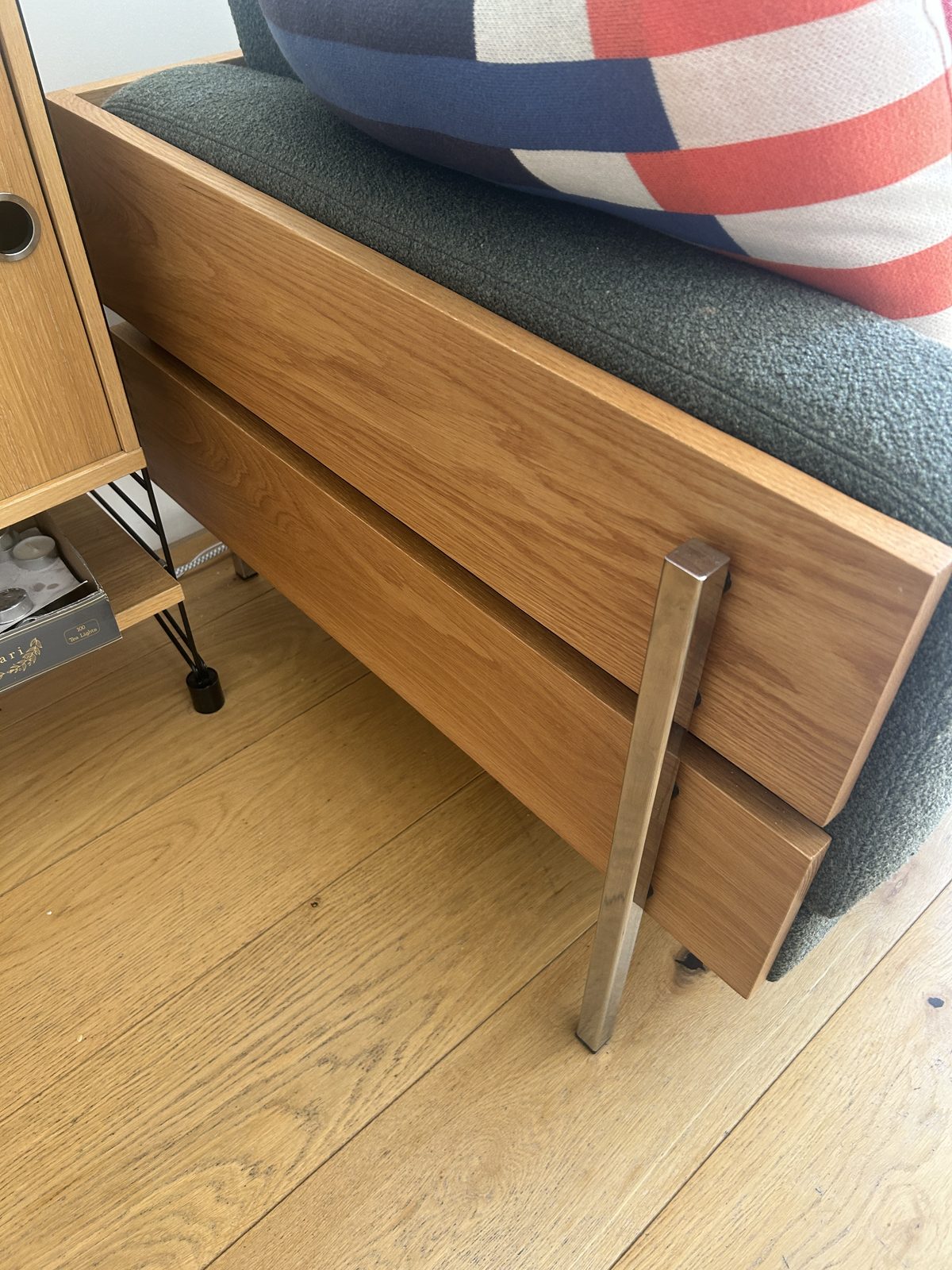 Close-up of the Forum sofa's oak frame and chrome leg, mounted outside the frame