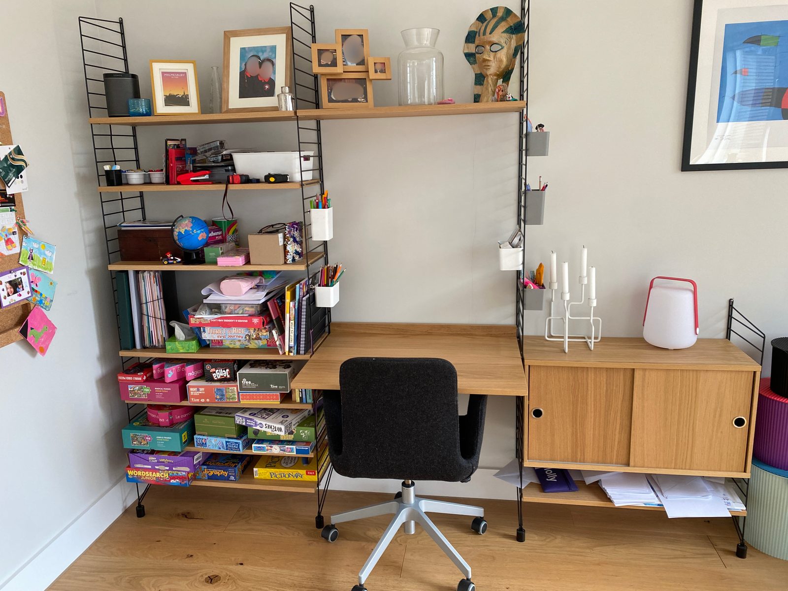 String shelving in its original desk configuration, with an office chair and desk surface