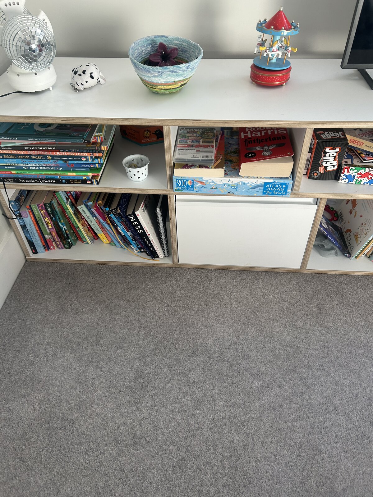 Close-up of the shelf top, with books, games and odds and ends