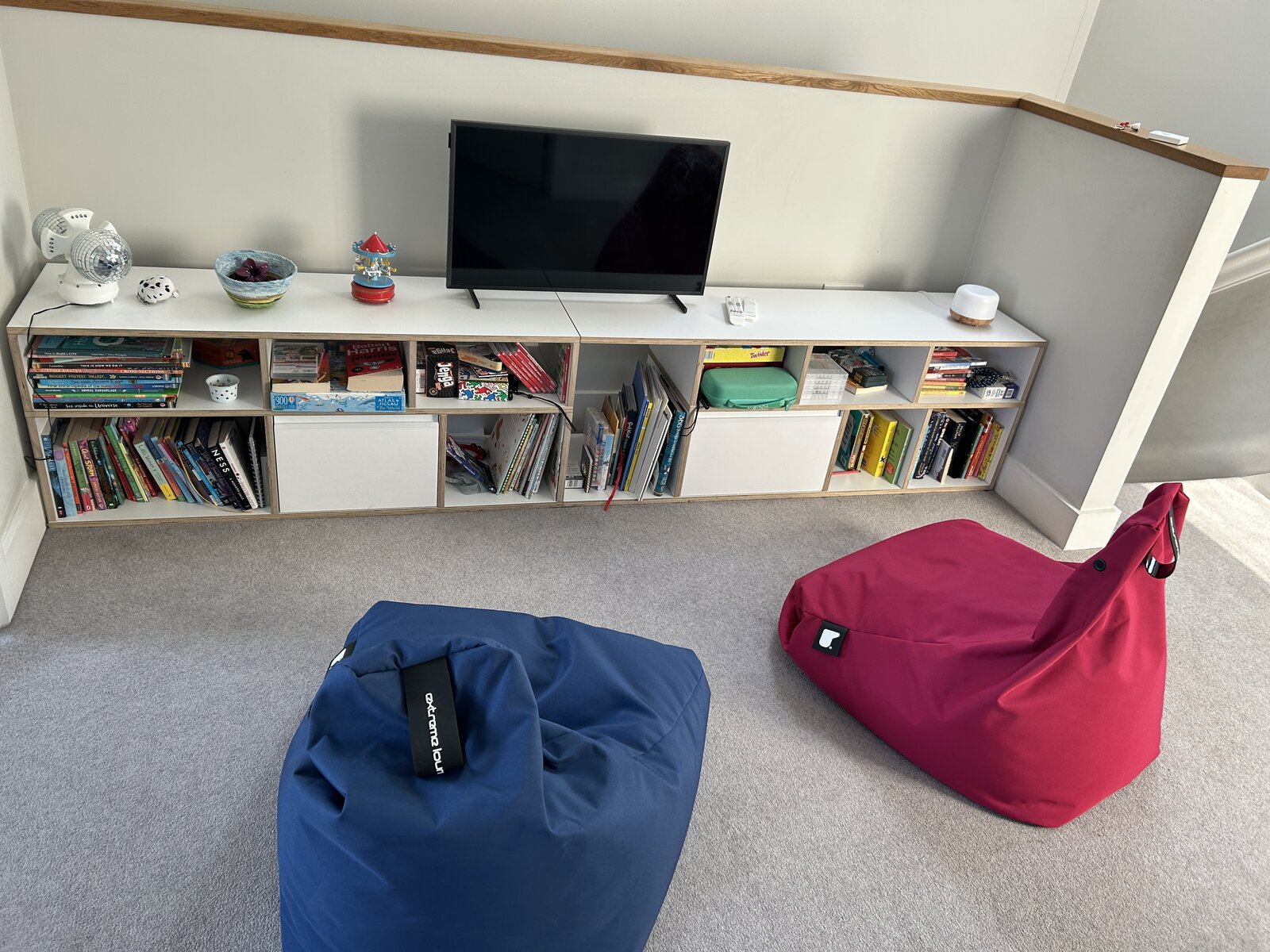 The Tylko unit holding the TV, books and games, with the blue and pink bean bags in front